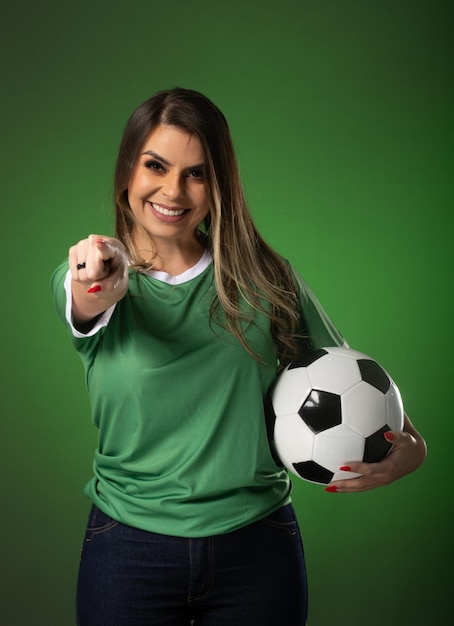 Woman soccer fan cheering for her favorite club and team world cup green background