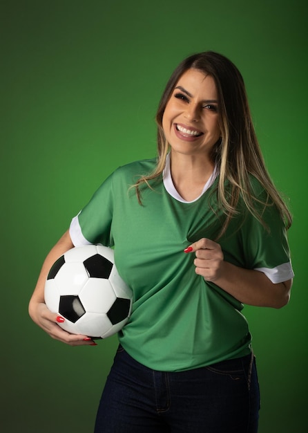 Woman soccer fan cheering for her favorite club and team world cup green background