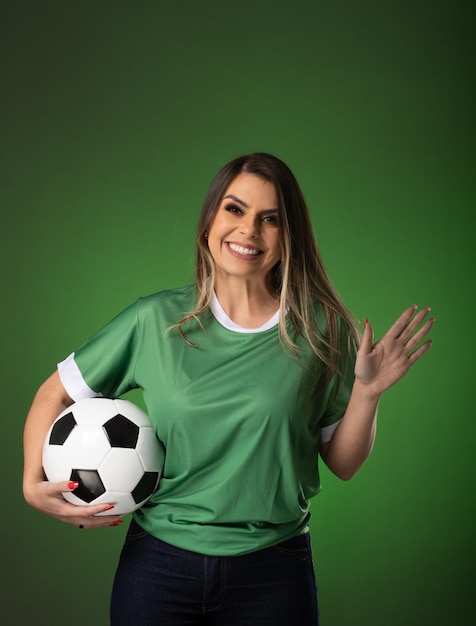 Woman soccer fan cheering for her favorite club and team world cup green background