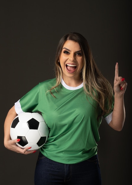 Woman soccer fan cheering for her favorite club and team world cup green background