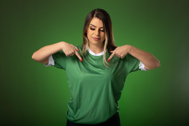 Woman soccer fan cheering for her favorite club and team world cup green background