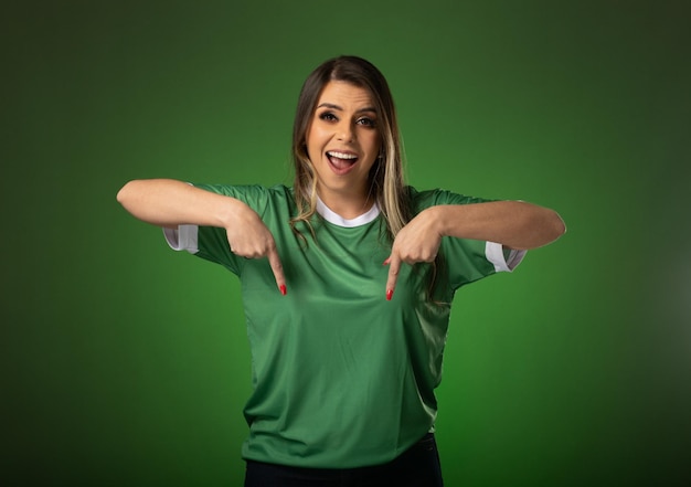 Woman soccer fan cheering for her favorite club and team world cup green background