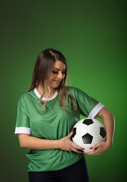 Woman soccer fan cheering for her favorite club and team world cup green background