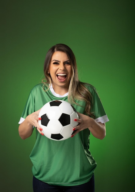 Woman soccer fan cheering for her favorite club and team world cup green background