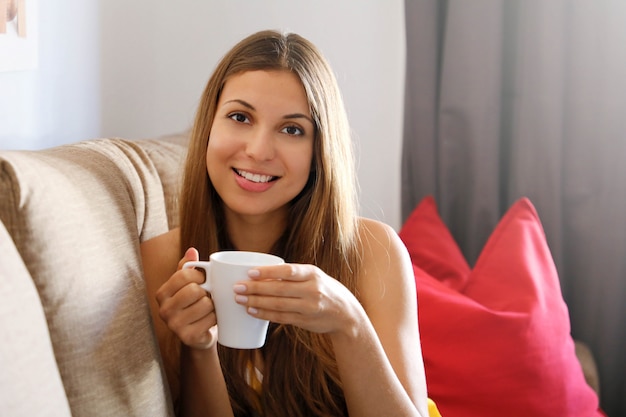 Woman on sofa holding a mug of coffee