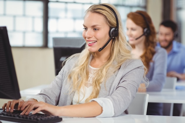 Woman speaking over headset while working 