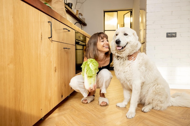 Woman spends leisure time dog while cooking healthy food in kitchen