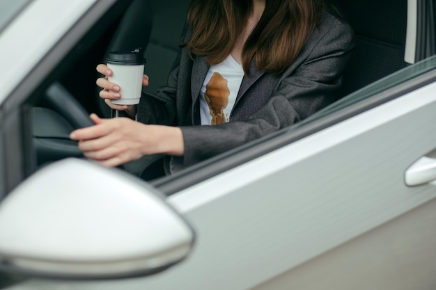 Woman spilled hot coffee on yourself while driving concept of cleaning stains on clothes