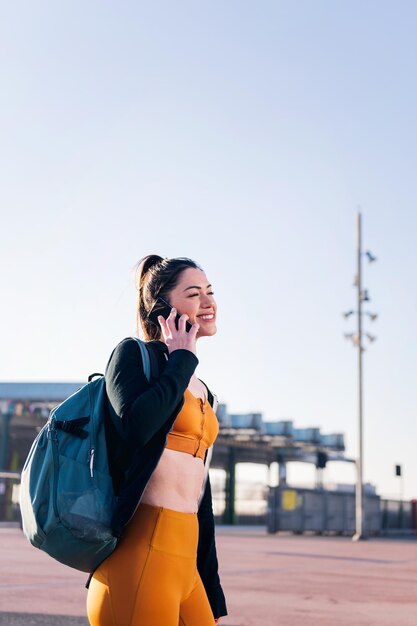 Woman in sports clothes talking by mobile phone