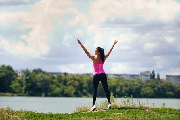 woman in sportswear is playing sports on a lake in the city