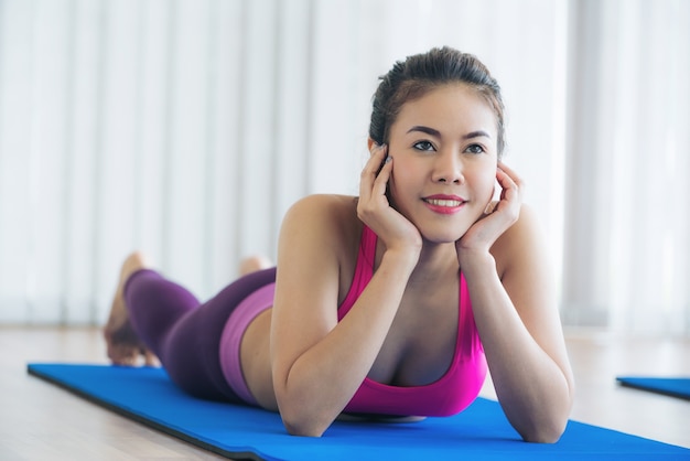 Woman in sportswear practice yoga workout stretching in indoors gym.