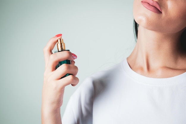 Woman sprinkles perfume on her neck