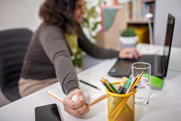 Woman squashing anti stress ball in her hand to reduce stress at office