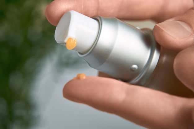 Woman squeezes the cream out of the tube. Close up image of hands with cream tube