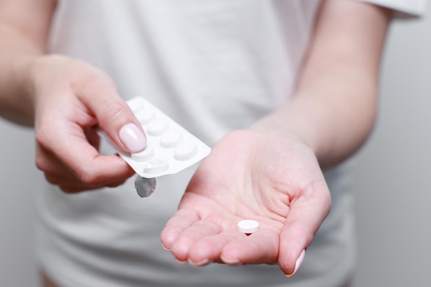 The woman squeezes the pill into her hand closeup medications for the disease