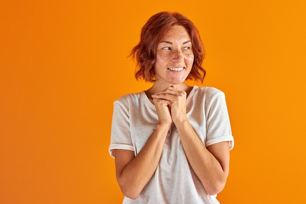 woman stand dreaming about something and looking away over orange. dreams