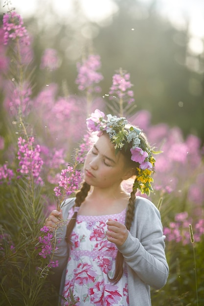 Woman standing by pink flowering plants