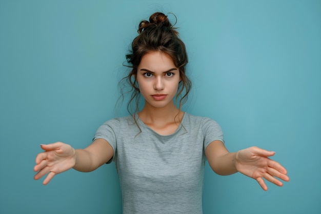 Photo a woman standing in front of a blue wall with her hands out