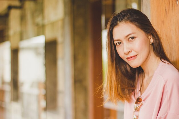 Woman standing leaning against a wooden door.