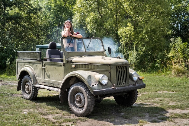 Woman standing in military car posing outdoors