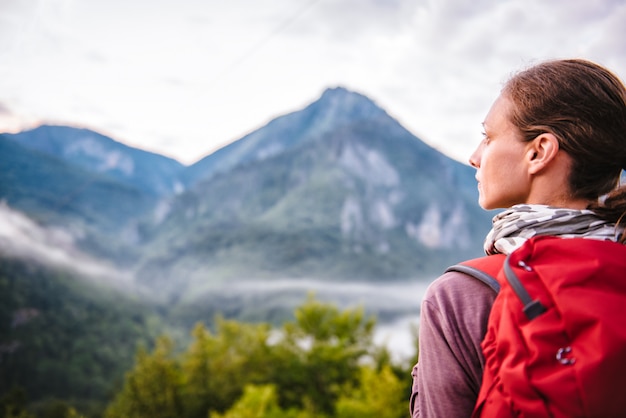 Woman standing on mountain and looking sideways