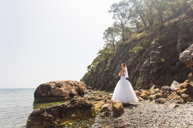 Photo woman standing on rock by tree against sky