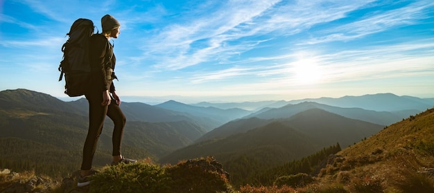 The woman standing on the rock with a picturesque sunset