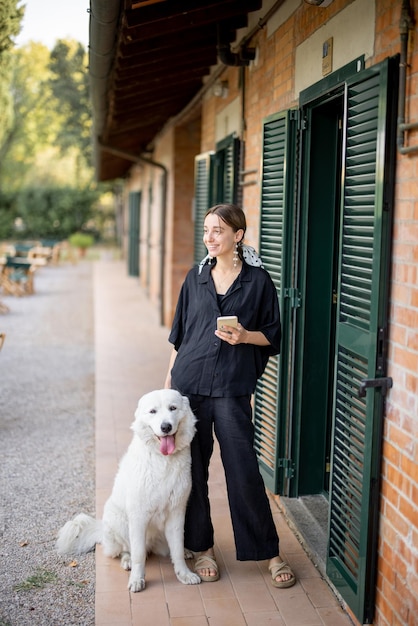 Woman standing with dog and looking away near entrance to hotel room