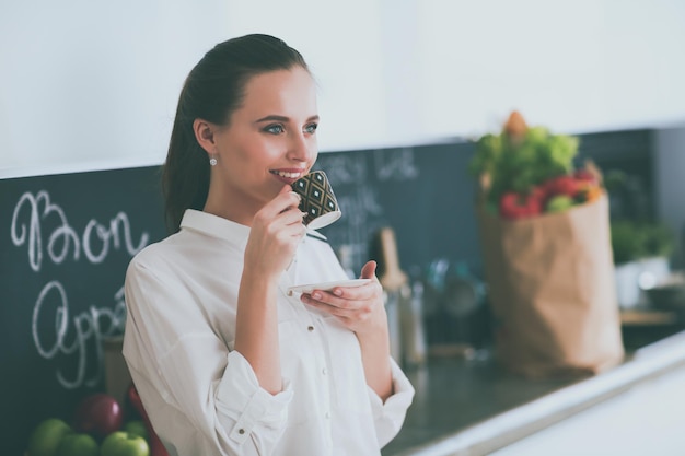 A woman stands in front of a chalkboard that says'food'on it