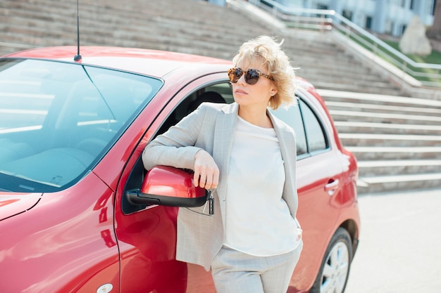 Woman stands near a broken car after an accident call for help car insurance