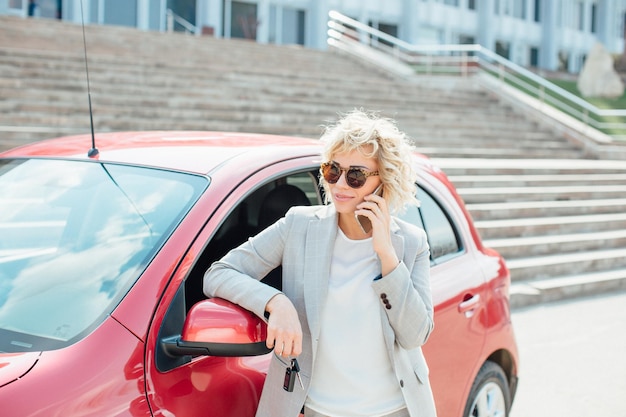 Woman stands near a broken car after an accident call for help car insurance