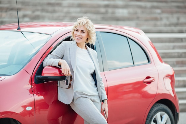 Woman stands near a broken car after an accident call for help car insurance