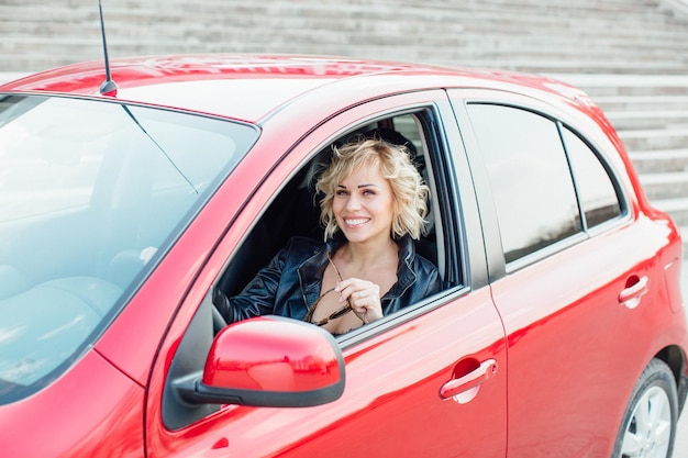 Woman stands near a broken car after an accident call for help car insurance