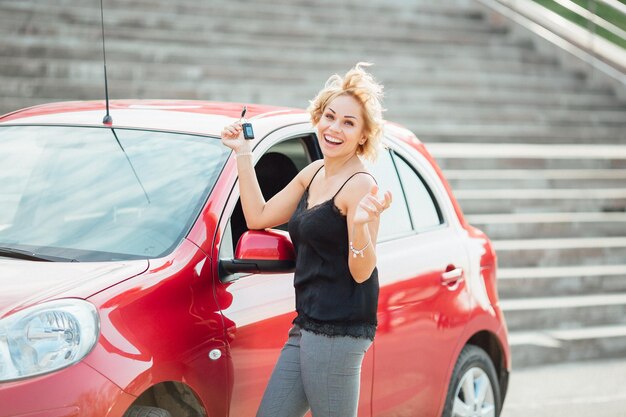 Woman stands near a broken car after an accident call for help car insurance