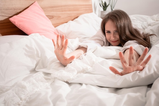 Woman starting her day stretching in bed