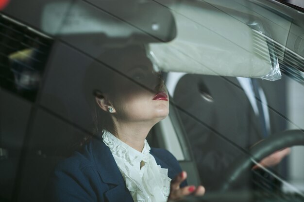 The woman the steering wheel of the carBusiness woman in the car interior through the glass