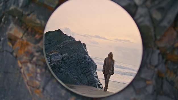 Photo woman stepping sunset beach in mirror reflection amazing evening sky at ocean