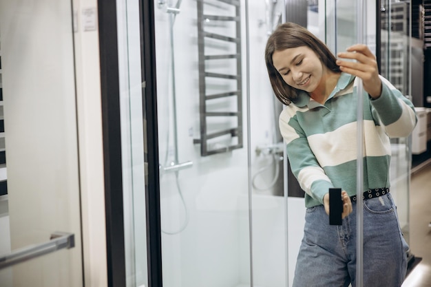 Woman in store choosing bath mixer