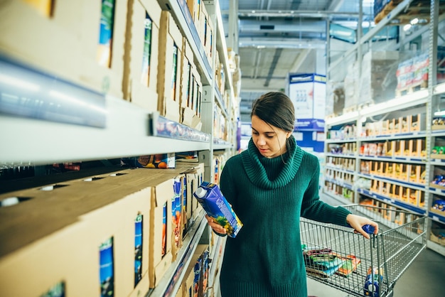 Woman in store read ingredients of juice. grocery shopping. copy space