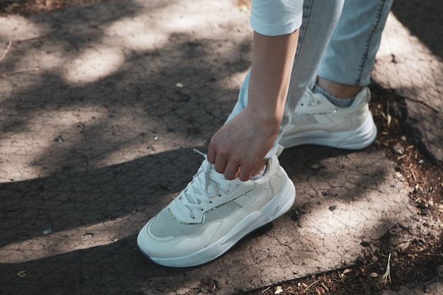 Woman straightens shoelaces in the park