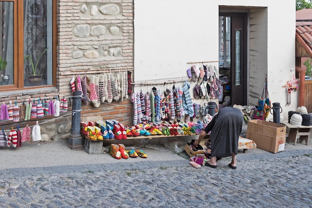 The woman next to a street shop selling knitwear