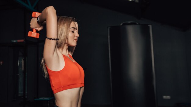 Woman stretching and doing exercises in the gym