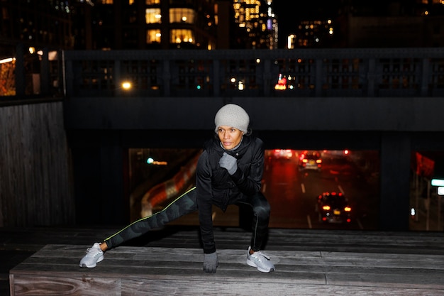 Woman stretching and exercising at night in the city