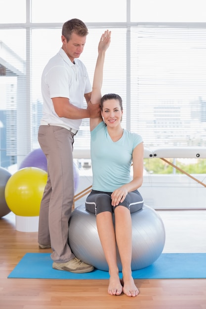 Woman stretching her arm with trainer