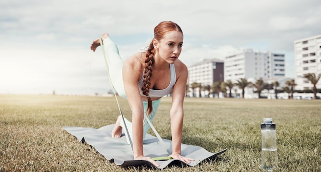 Woman stretching legs and resistance band in the city for workout exercise or training on yoga mat Female yogi in warm up leg stretch and elastic strap for healthy wellness or fitness in Cape Town