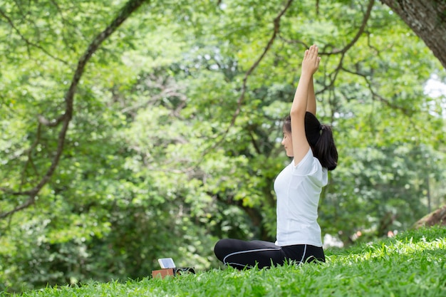 Woman stretching oneself with yoga posture in the nature. health concepts.