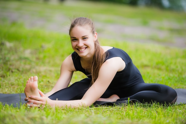 Woman stretching outdoors in a park before yoga practice