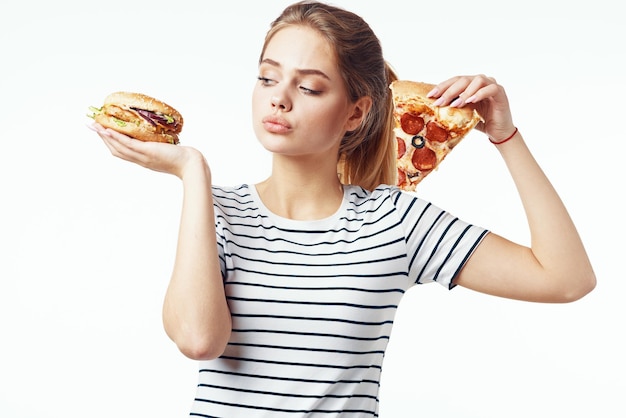 Woman in striped tshirt eating pizza fast food diet light background