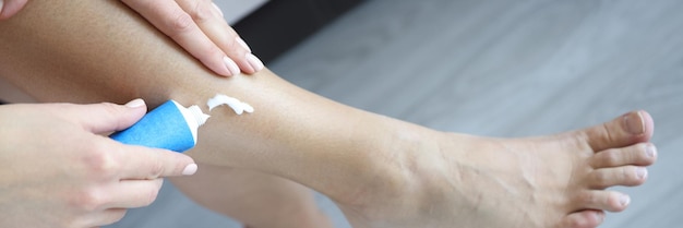 Woman strokes legs and applies moisturizer antivaricose care for beautiful legs