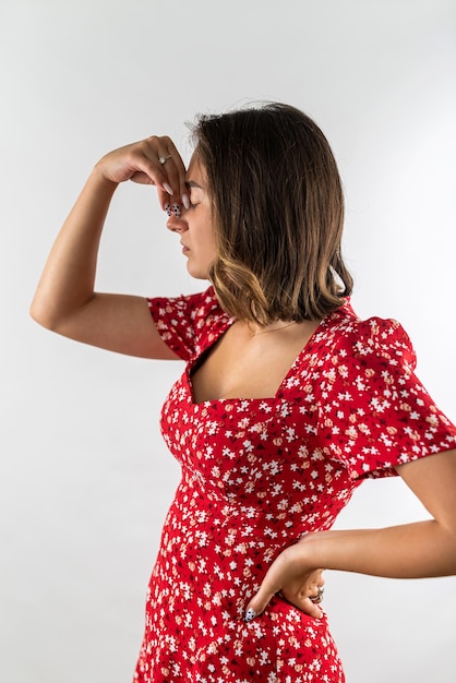 Woman suffering fro headache holding her hands behind her head isolated on a white background